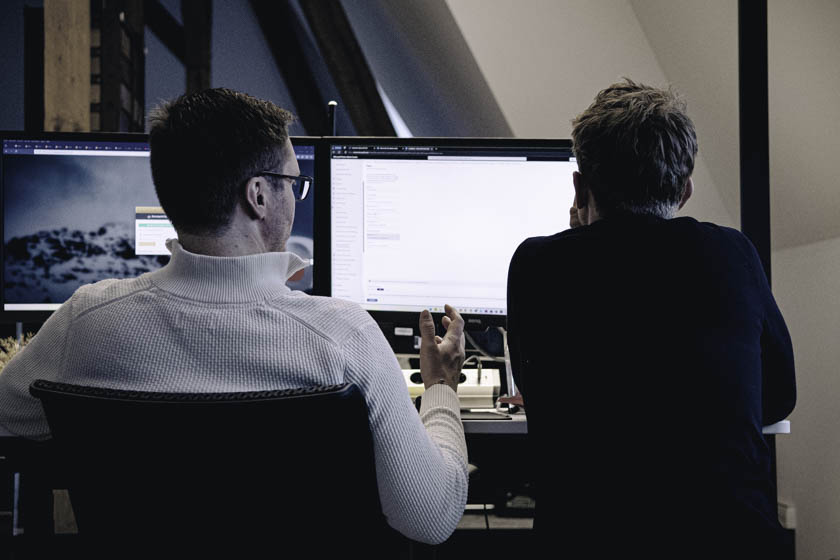 Büroalltag Stimmungsbild, zwei Mitarbeiter vor PC